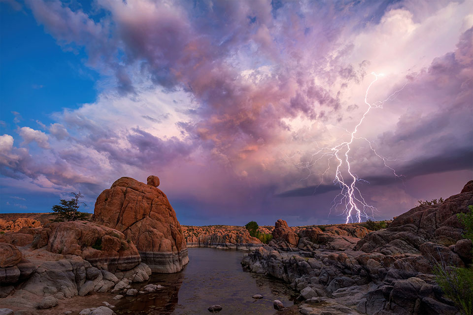 Lightning strikes at Watson Lake under colorful skies. Photograph by Theresa Rose Ditson.