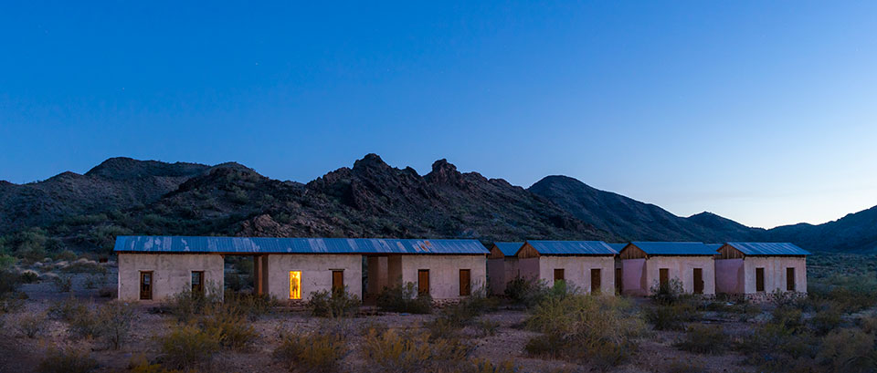 A view of the miners’ quarters in Swansea also shows the surrounding Buckskin Mountains — and a ghostly glimpse of our photographer. By John Burcham