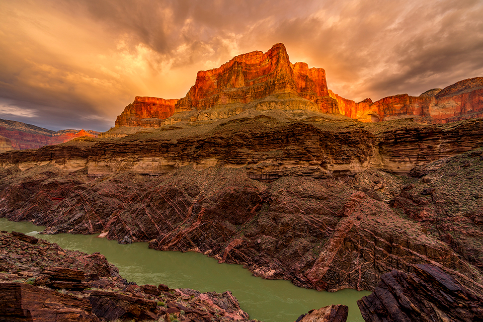 The Colorado River flows through Granite Gorge, a rugged section of the Canyon, at sunset in a view from the north side of the river. Granite Gorge is known for its exposed sections of the Canyon’s oldest rock layers, some of which formed about 1.8 billion years ago.