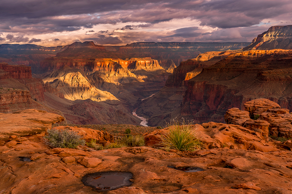 A storm clears at sunset in a view from the Esplanade, a layer of the Canyon known for sandstone formations and backcountry hiking opportunities. This vantage point, which looks upstream, is near the tip of Fishtail Mesa, on the North Rim, and offers a view of Steamboat Mountain.