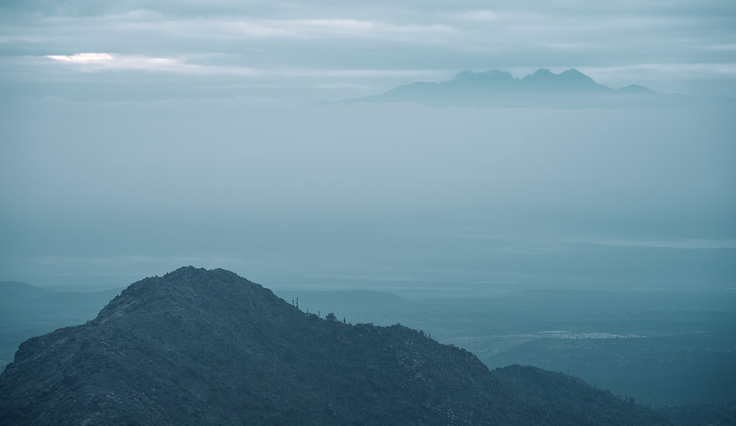 Fog shrouds desert peaks in a view from Bell Pass in the McDowell Mountains. By Eric Mischke