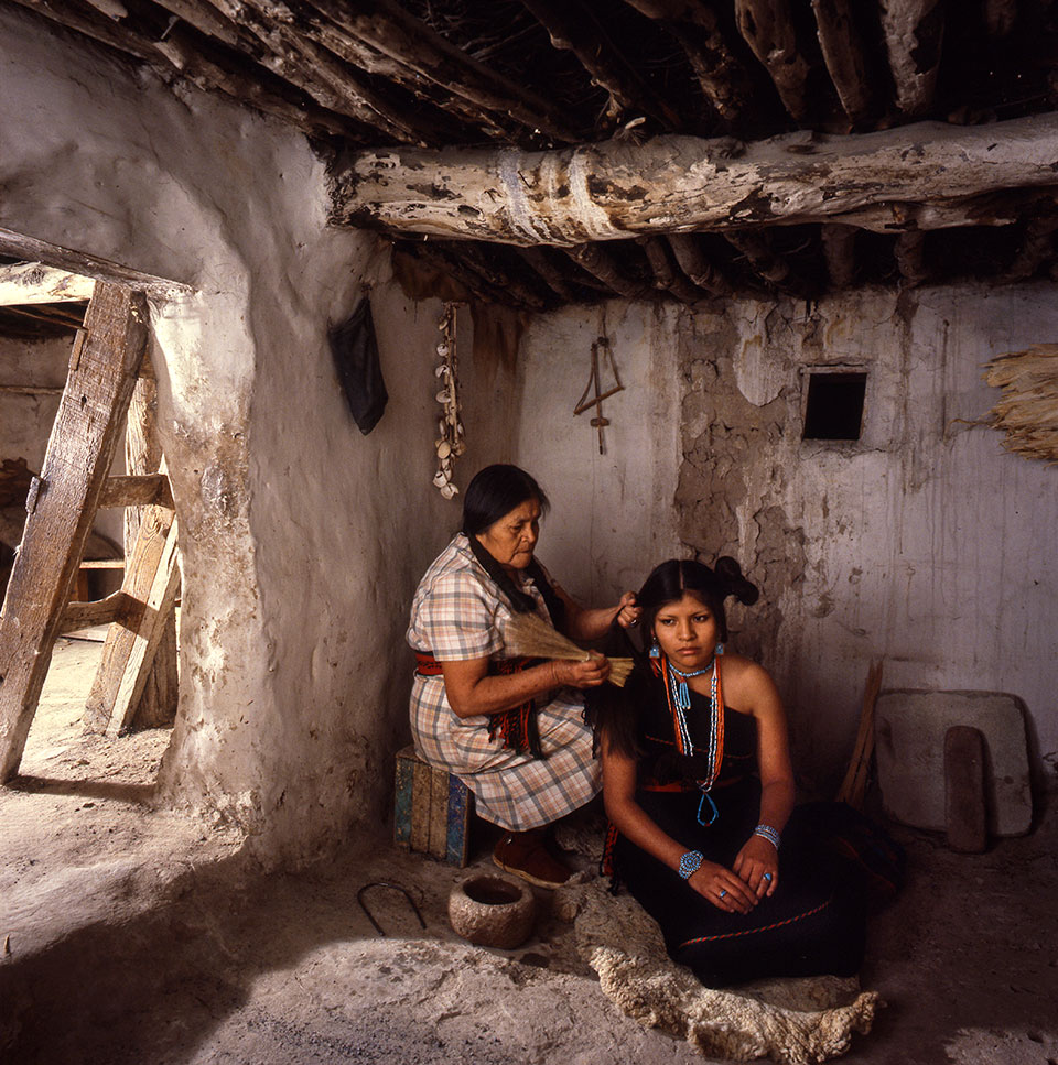 Wearing a traditional dress called a manta, Carol Dawahoya has her hair styled in a butterfly whorl, or maiden’s whorl, by aunt Hazel Dukepoo. Once worn by all eligible unmarried Hopi women, the elaborate coif now is used only for special ceremonies.