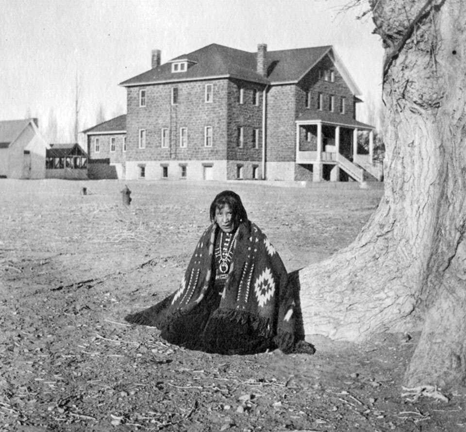  A Navajo girl wears tribal garb outside a boarding school in Tuba City in 1919. | Northern Arizona University Cline Library