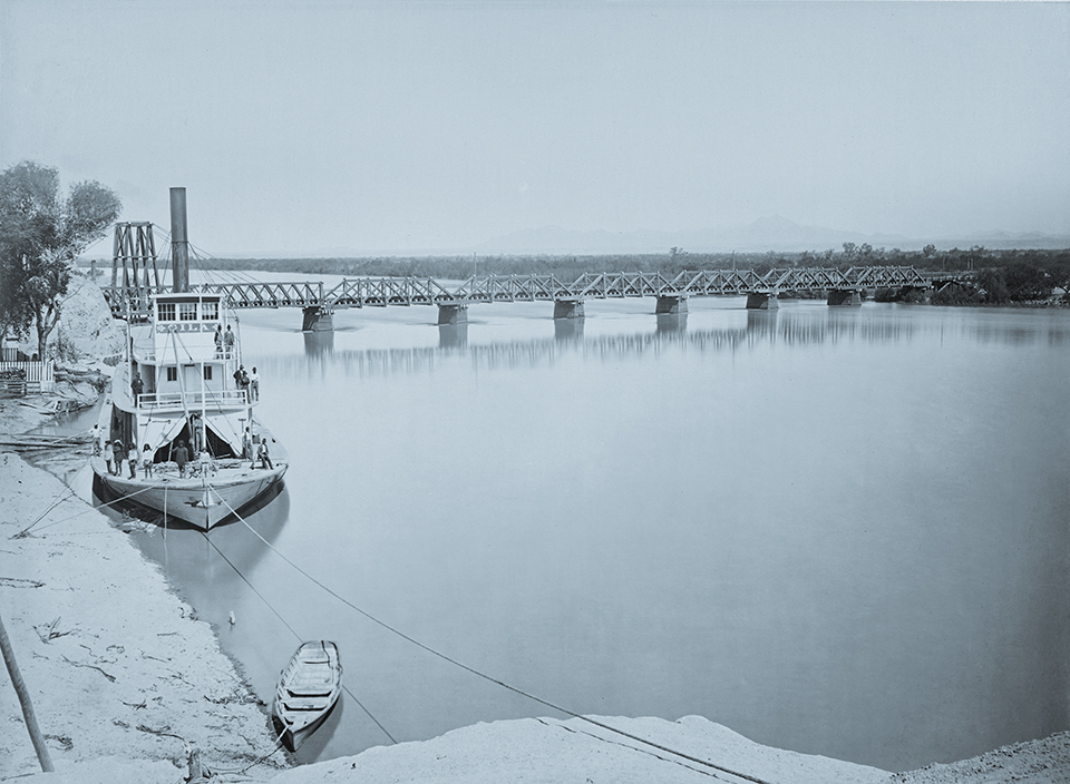 Behind the moored steamboat Gila, a bridge used by the Southern Pacific Railroad spans the Colorado River at Yuma in a photo from the late 1870s or early 1880s. In the 1920s, a new railroad bridge was built in a less flood-prone location; it’s still in use today, right next to the Ocean-to-Ocean Highway Bridge. | THE BANCROFT LIBRARY, UNIVERSITY OF CALIFORNIA, BERKELEY