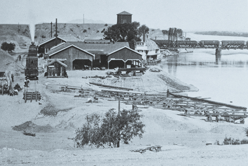 The Gila might also be the steamboat visible in this 1878 photo of the Colorado Steam Navigation Co.’s facility in Yuma. In the background, a train can be seen crossing the original railroad bridge. | THE HUNTINGTON LIBRARY