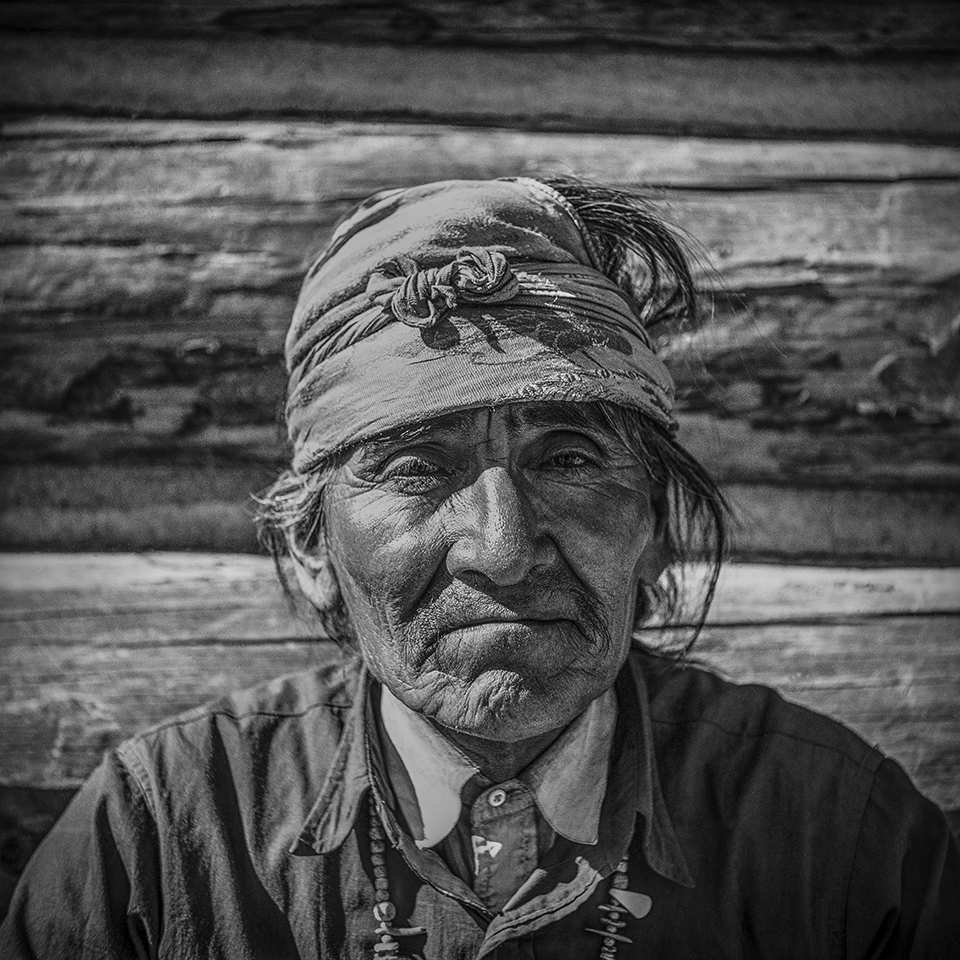 BW portrait of Navajo man in front of a log wall by Barry Goldwater