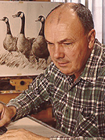 Larry Toschik at his drawing board working on an illustration of water fowl. Portrait of Carlos Elmer with camera. | COURTESY OF THE TOSCHIK FAMILY