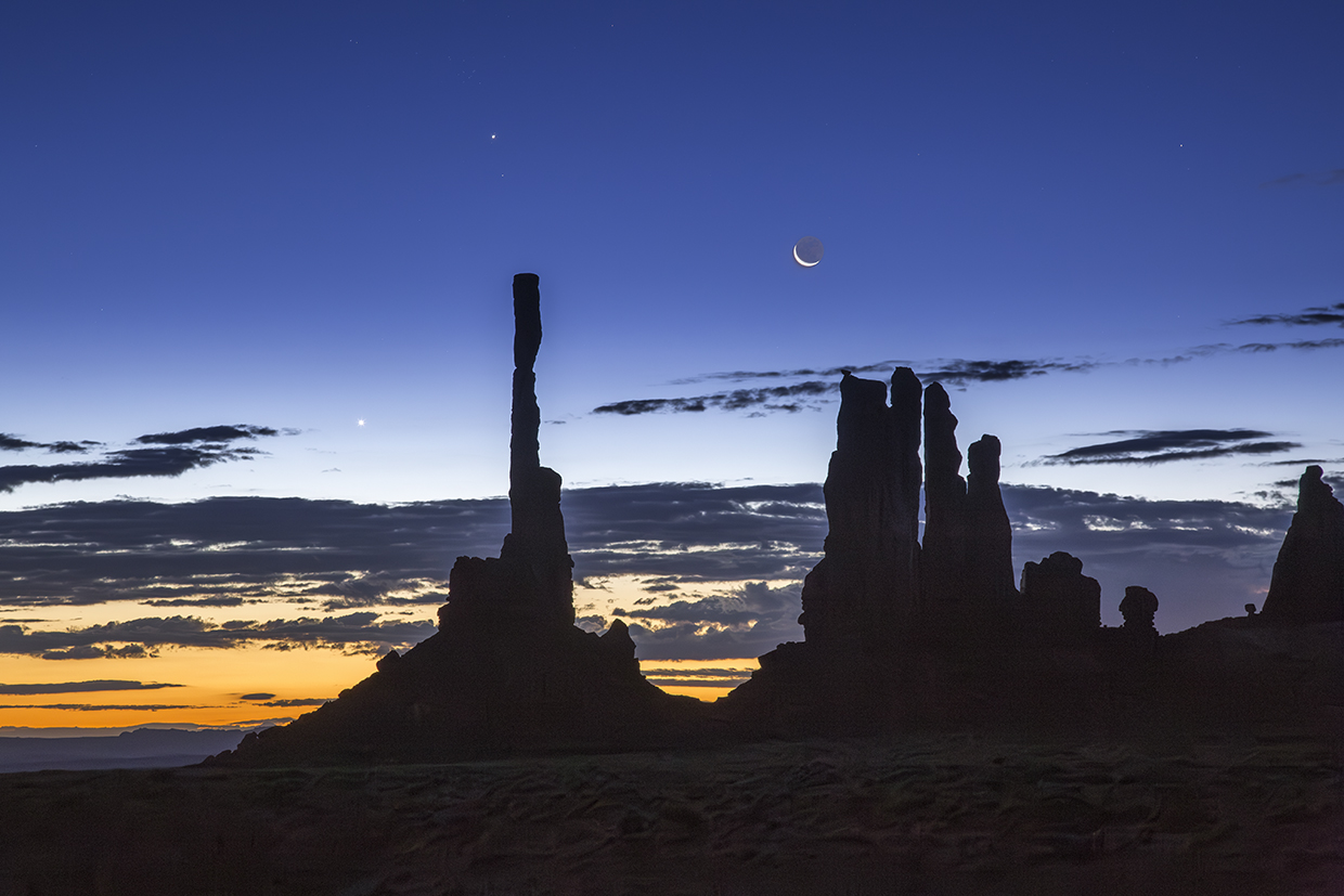 Dawn and night briefly share the sky over Ye Bi Chei at Monument Valley, in Northeastern Arizona. The Navajo people, on whose land this photograph was made, have strong spiritual beliefs tied to the moon. By Suzanne Mathia