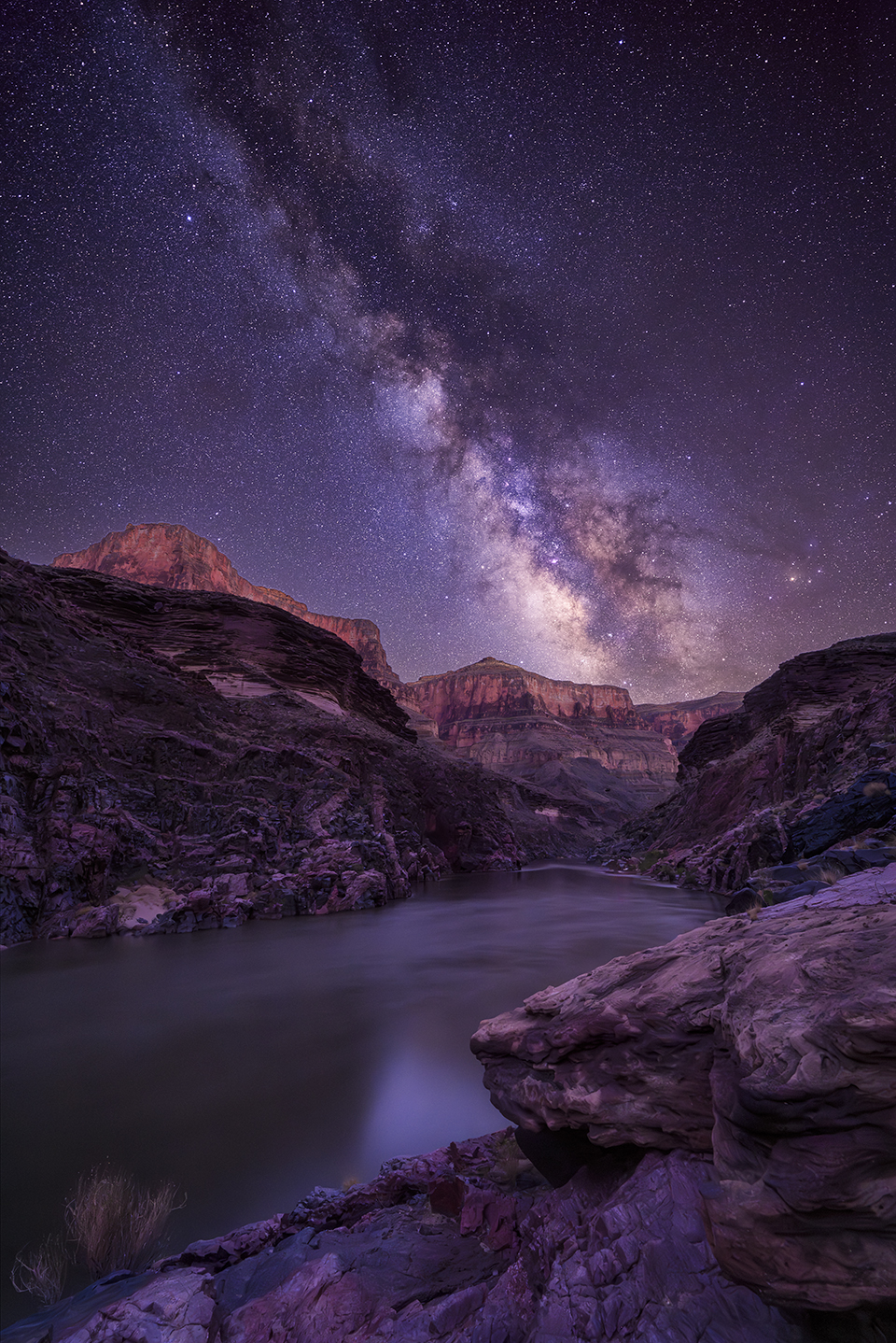 The Milky Way looms over the Colorado River as it flows through the Canyon. This view is from a rafting campsite along the river, looking downstream. | Shane McDermott