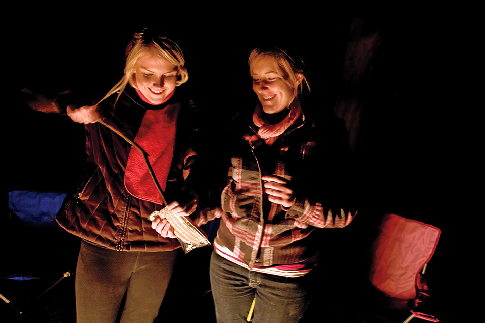 Lexi and Lyndsay prepare dinner over an open fire. | Peter Schwepker