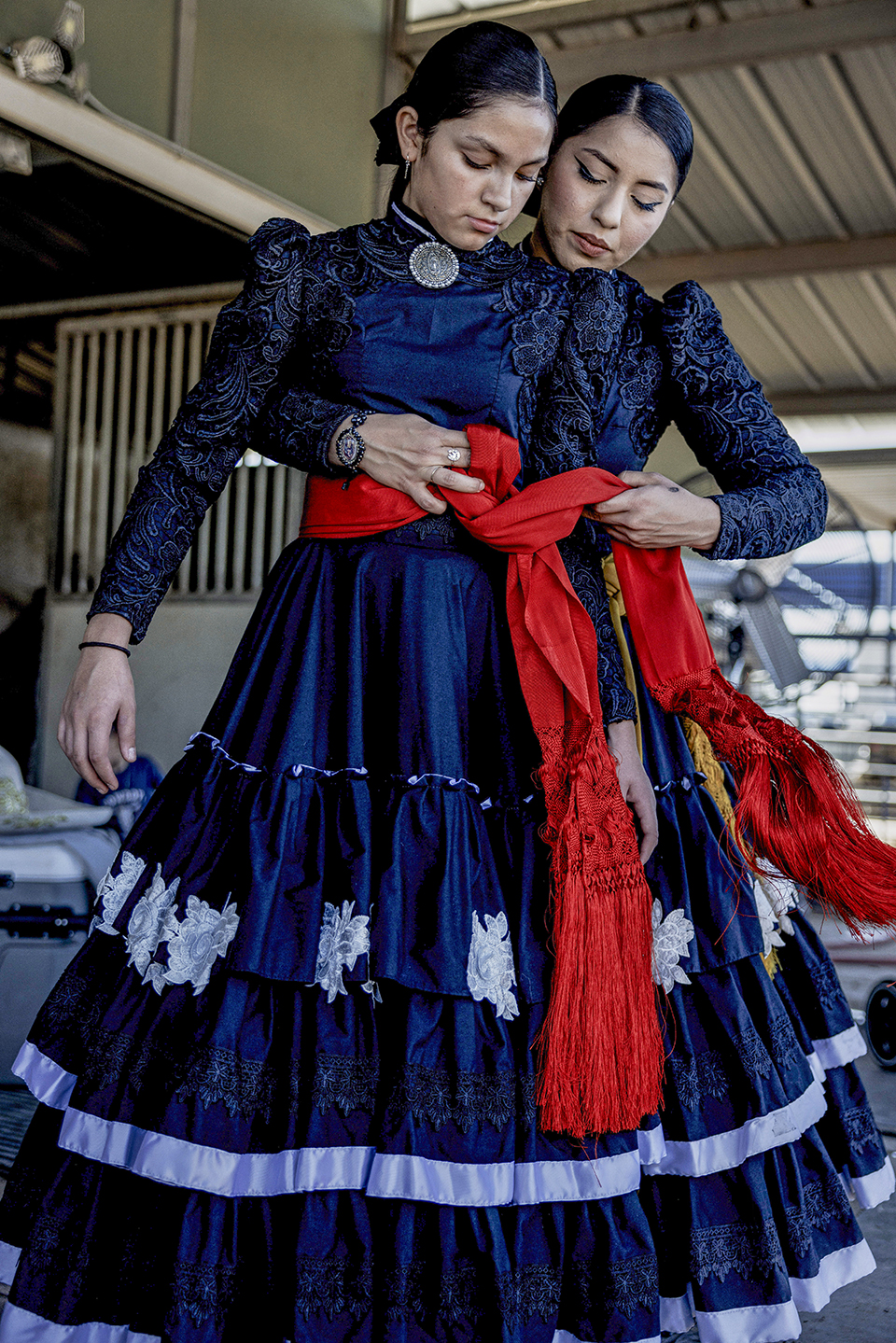 Amazonas de Corazón teammates Ana Ochoa (left) and Sol Reyes adjust their uniforms for an event at Rancho Corona. Ana is the granddaughter of longtime escaramuza rider Yolanda Campos. | Adriana Zehbrauskas