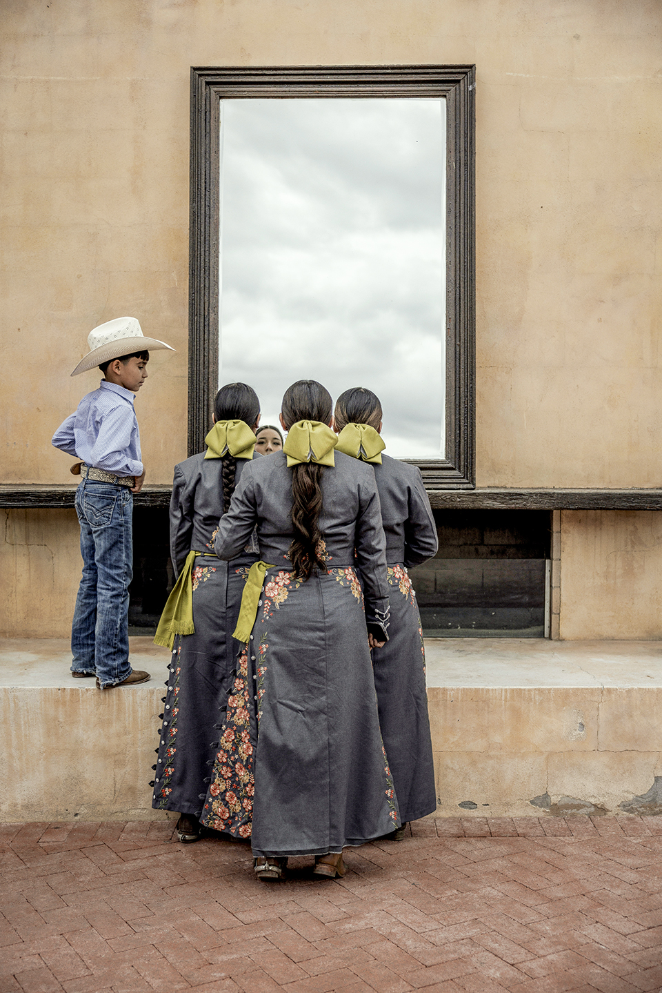 Team members check their makeup and ornate uniforms in a mirror before starting their performance. | Adriana Zehbrauskas