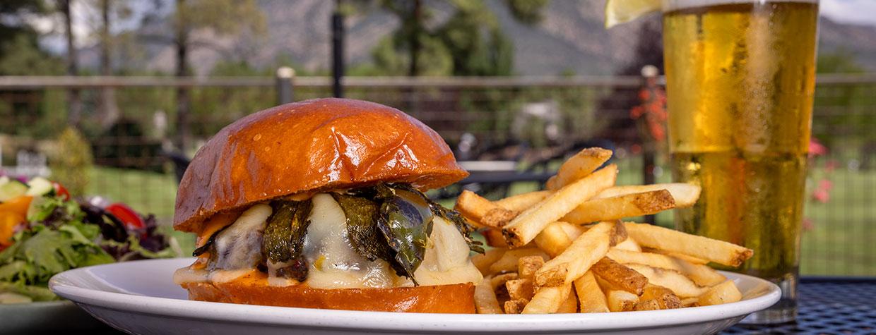 Burger, fries and beverage on patio with San Francisco Peaks in background. By John Burcham