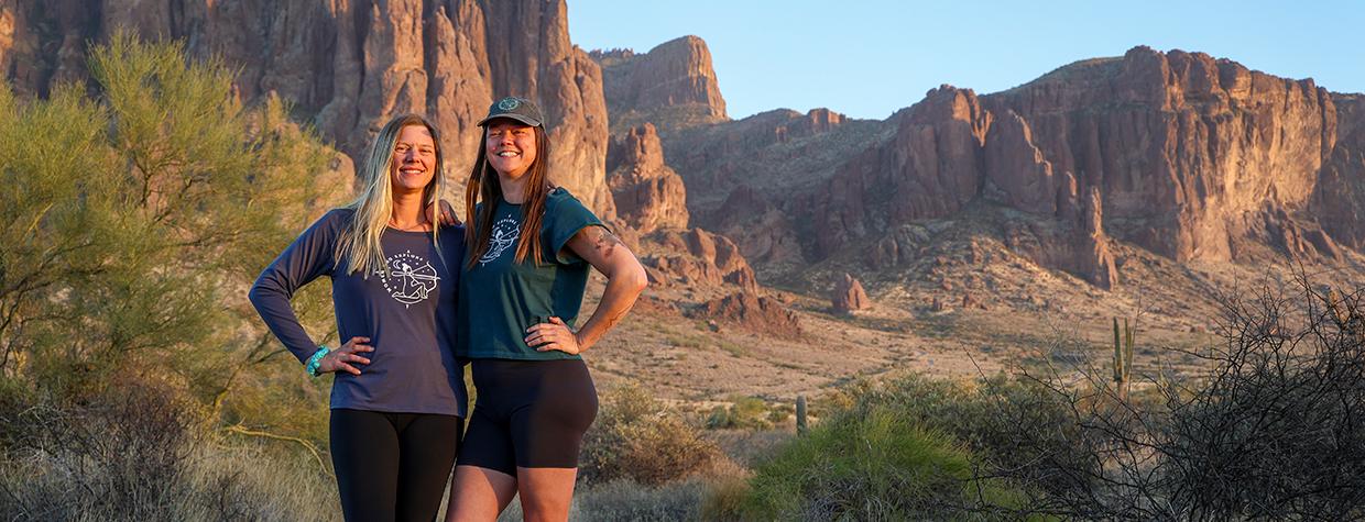 Lindsey Egan (left) and Melissa Wright pose in a desert setting with the Superstition Mountains in the background. By Shondiin Mayo