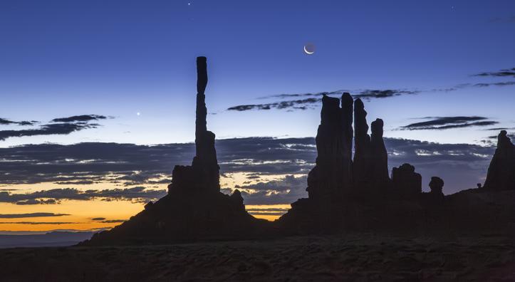 Dawn and night briefly share the sky over Ye Bi Chei at Monument Valley, in Northeastern Arizona. The Navajo people, on whose land this photograph was made, have strong spiritual beliefs tied to the moon. By Suzanne Mathia