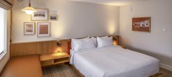 The interior of a room at Trailborn Grand Canyon features a large bed, sitting area and a desk. By John Burcham