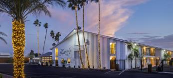 The Kennedy Hotel is pictured at twilight surrounded by lighted palm trees. By Steven Meckler